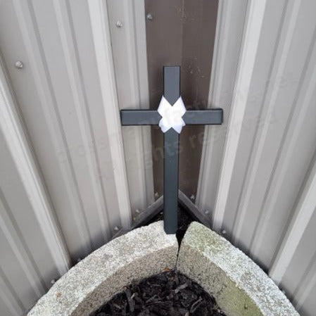 An 18 inch black STEEL cross with a white bow-tie design in the center designed as a baby memorial cross.